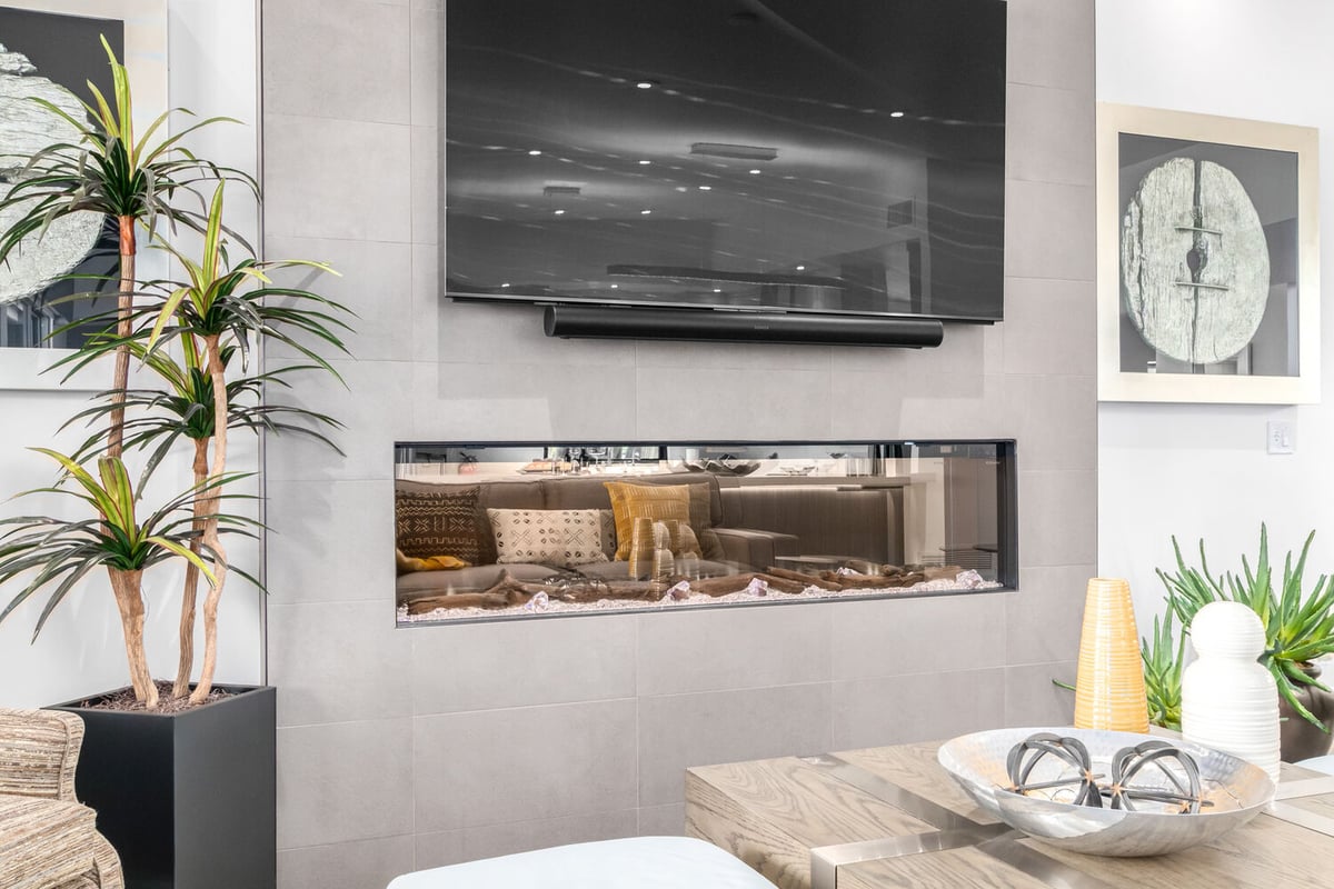 Close-up of modern fireplace in custom home by Kitchens by Good Guys in Glendale, AZ with sleek TV and neutral decor.