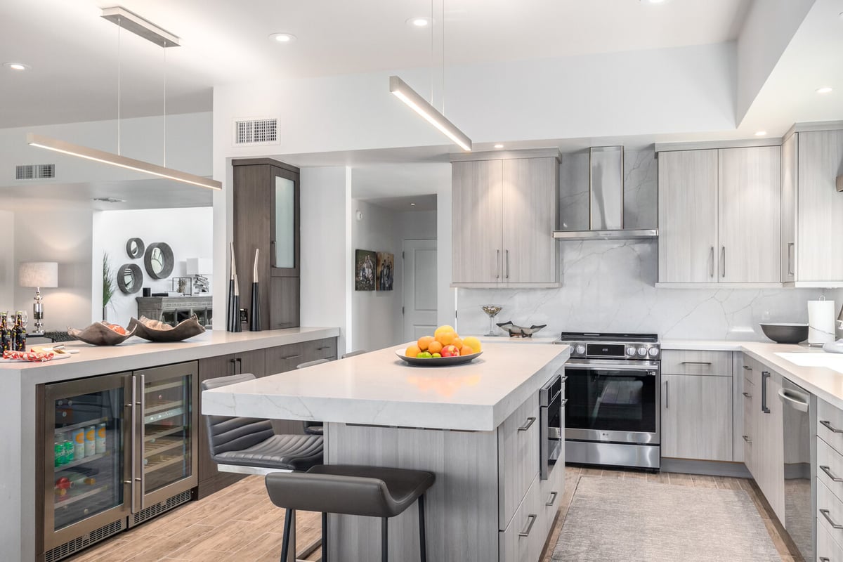 Light-filled custom kitchen design with stainless appliances and fruit centerpiece by Kitchens by Good Guys in Phoenix, AZ.