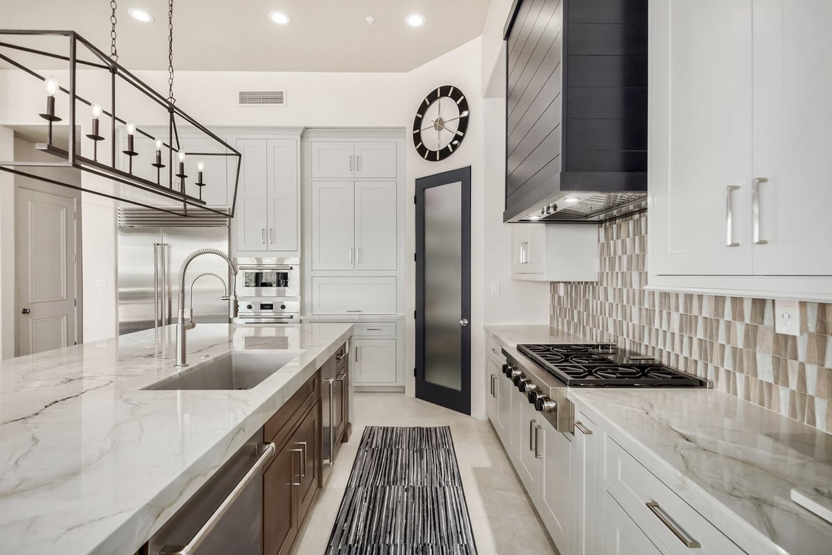 Custom kitchen design featuring frosted pantry door and statement wall clock by Kitchens by Good Guys in Paradise Valley.