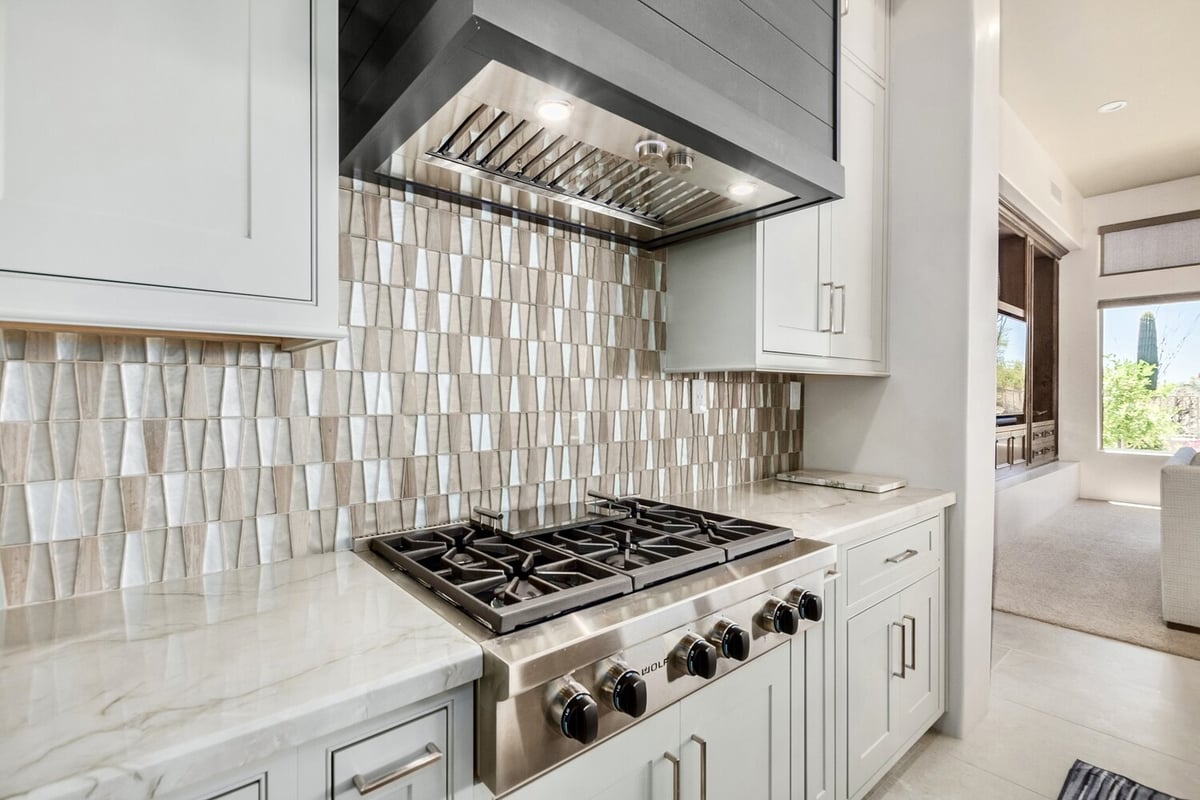 Custom kitchen with gas range and geometric backsplash by Kitchens by Good Guys in Scottsdale, AZ.
