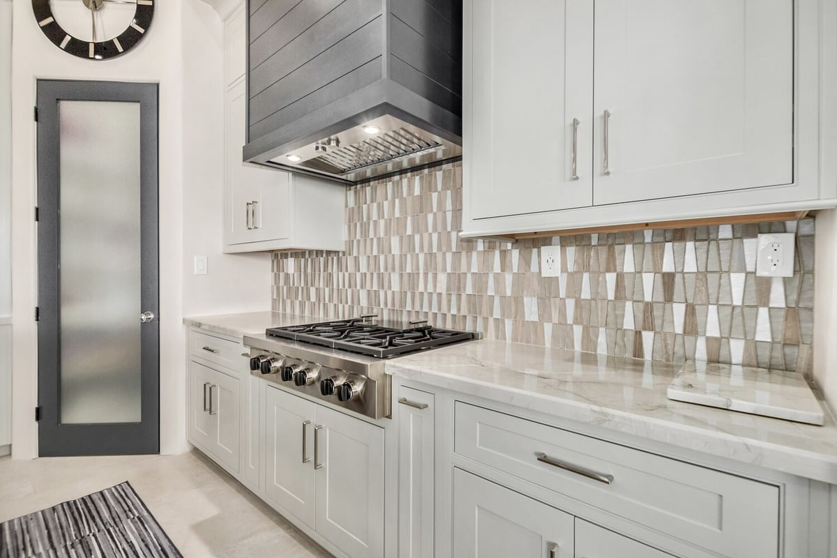 Designer kitchen range wall with black hood and dimensional tile backsplash by Kitchens by Good Guys in Scottsdale.