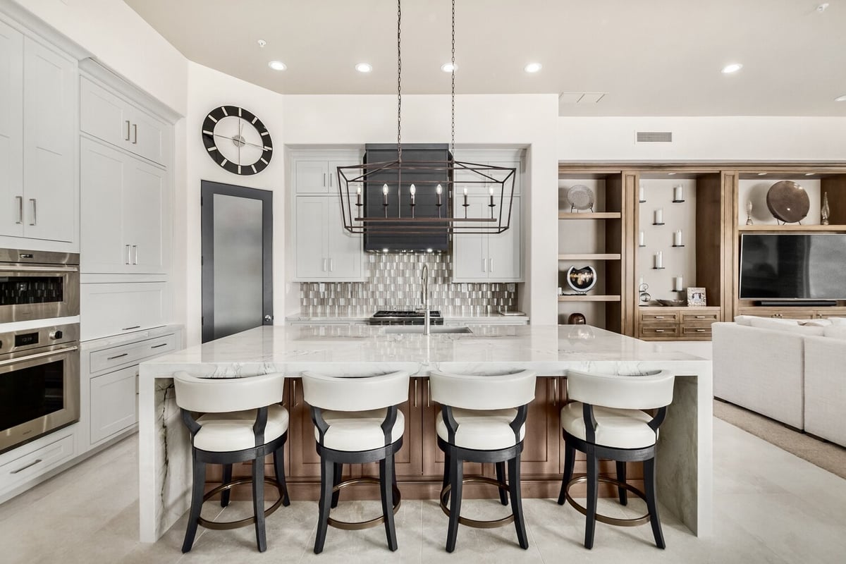 Elegant kitchen with large marble island and designer backsplash in Mesa home by Kitchens by Good Guys.