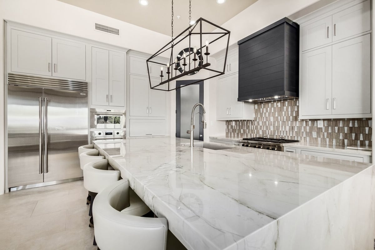 Full kitchen view featuring marble island and pendant chandelier by Kitchens by Good Guys in Arizona.