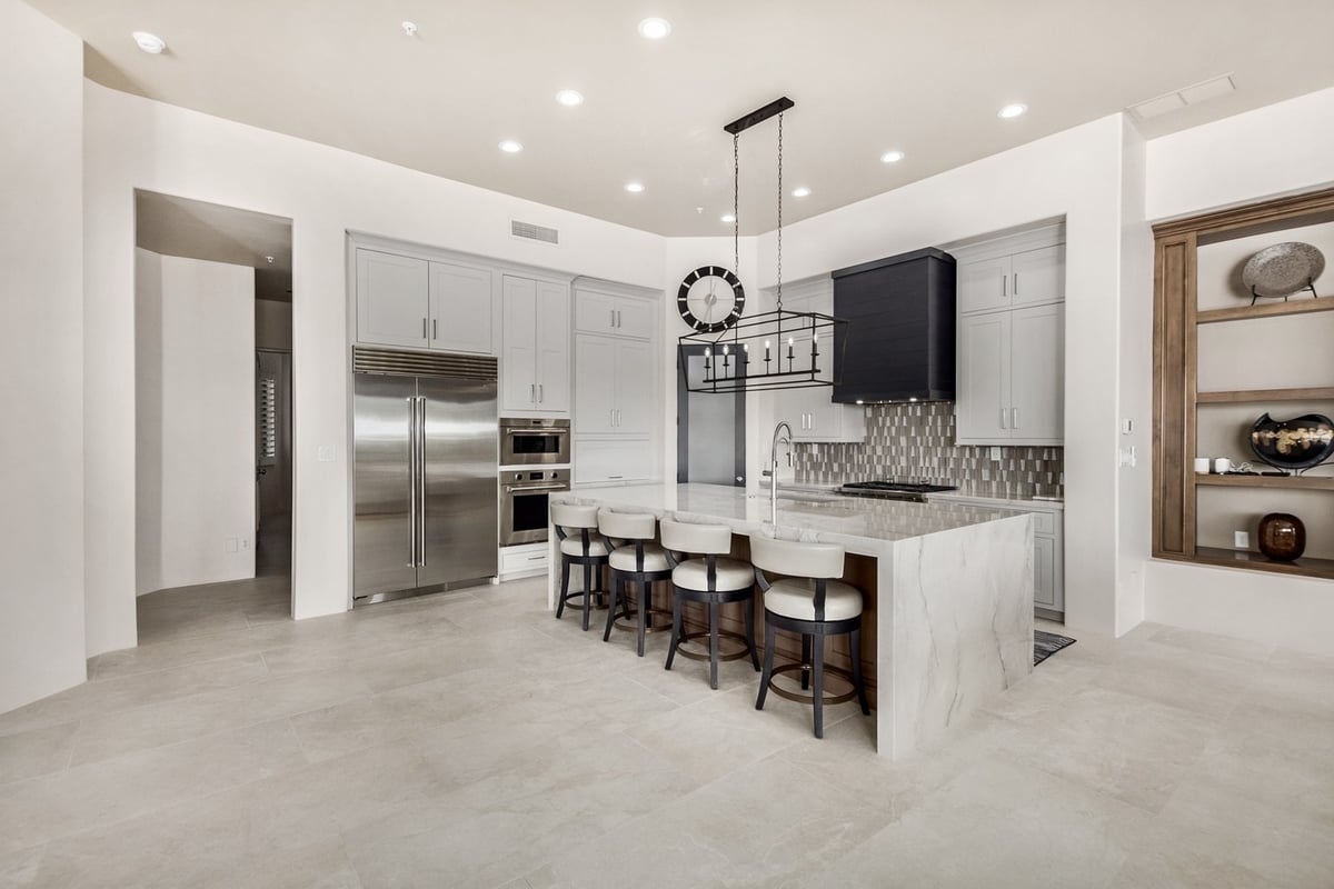Full view of luxury kitchen with bar seating and geometric backsplash by Kitchens by Good Guys in Mesa, AZ.