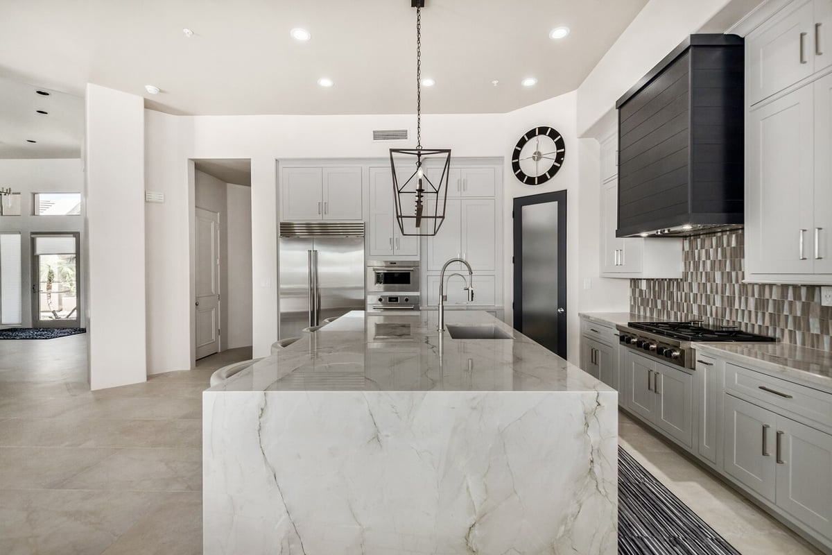 Polished marble waterfall island with built-in sink in Paradise Valley kitchen by Kitchens by Good Guys.
