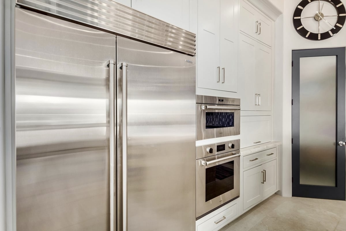 Sleek luxury kitchen with stainless appliances and marble surfaces by Kitchens by Good Guys in Scottsdale, AZ.