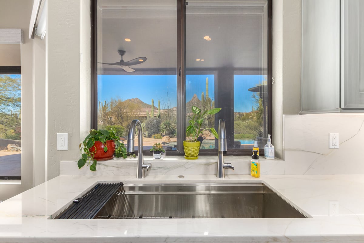 Close-up of double kitchen sink with scenic desert views in custom home by Kitchens by Good Guys in Rio Verde, AZ.