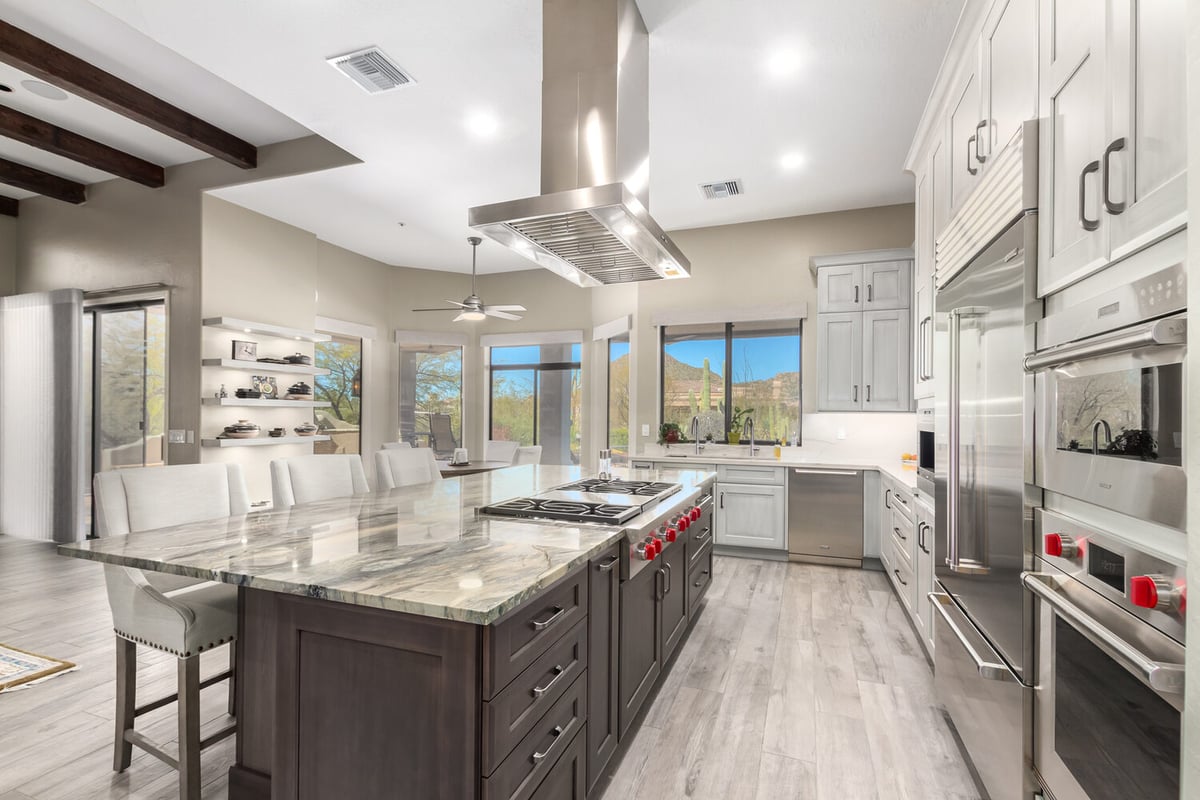 Large open kitchen with dual-tone cabinetry and range hood by Kitchens by Good Guys in Scottsdale, AZ.