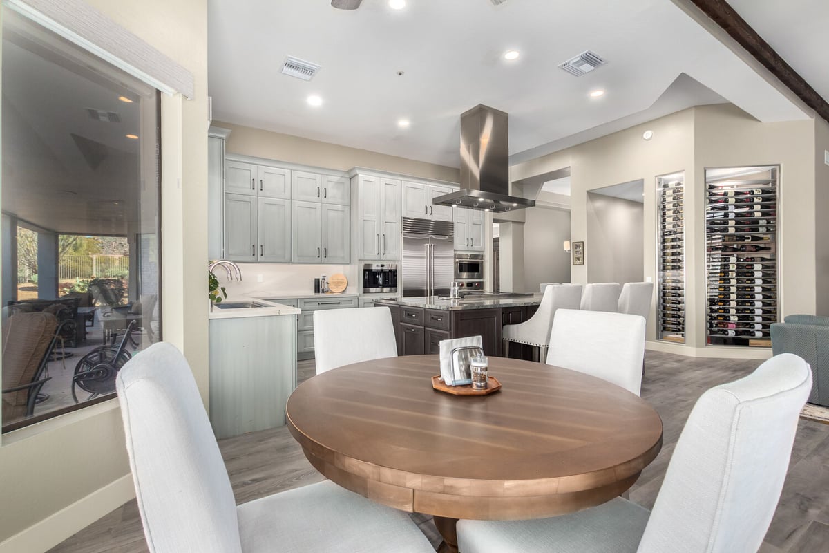 Open-concept kitchen and dining area with wine display in Scottsdale, AZ by Kitchens by Good Guys.