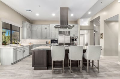Rear kitchen view with marble island and stainless range by Kitchens by Good Guys in Glendale, AZ.