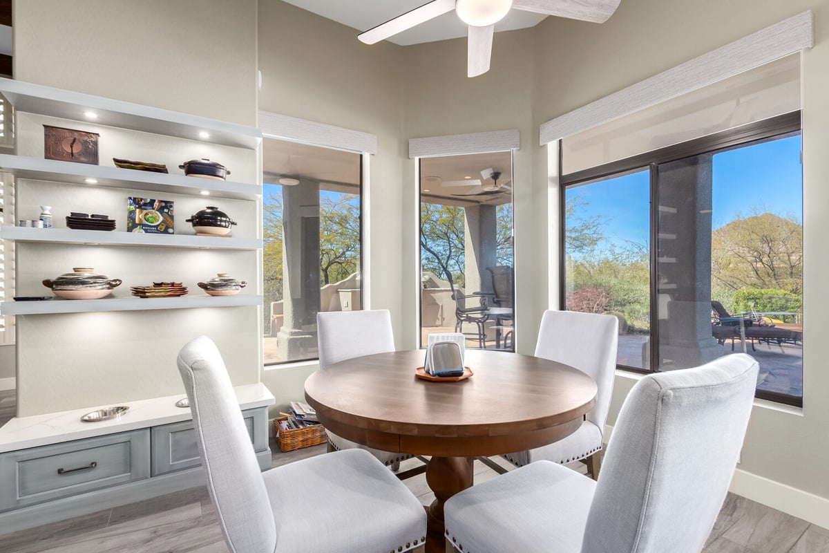 Round wood dining table with scenic desert views in Phoenix, AZ custom home by Kitchens by Good Guys.
