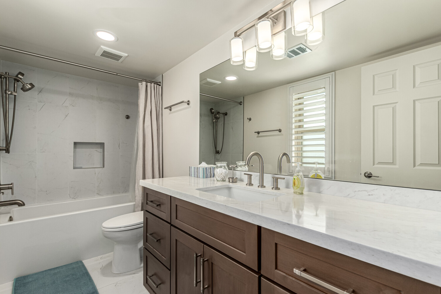 Bright bathroom with shaker cabinets and wall-mounted lighting in Scottsdale custom home by Kitchens by Good Guys.