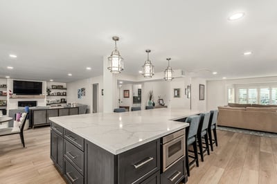 Open-concept kitchen with island seating and media wall in Scottsdale home by Kitchens by Good Guys.