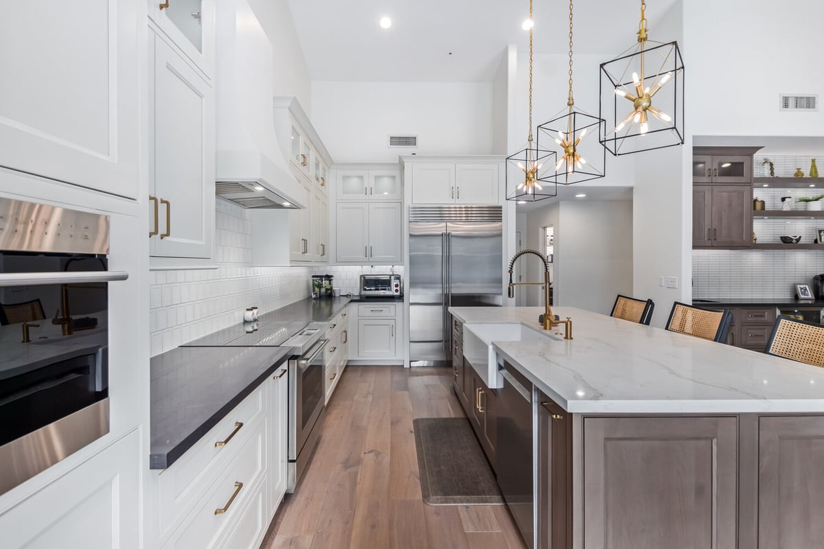 Gourmet kitchen with quartz island and brass fixtures in Scottsdale custom home by Kitchens by Good Guys.