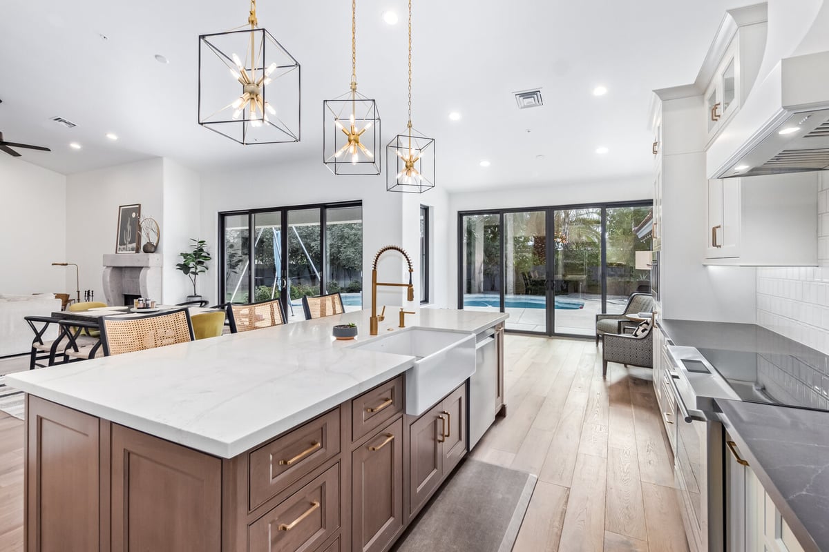 Kitchen island with farmhouse sink and dining view in Scottsdale custom home by Kitchens by Good Guys.