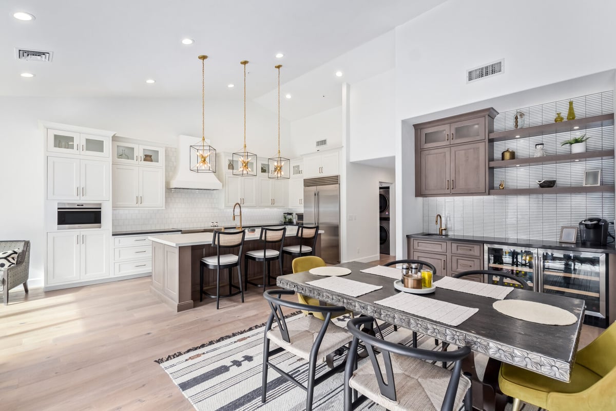 Open kitchen and dining room with modern lighting in Scottsdale custom home by Kitchens by Good Guys.