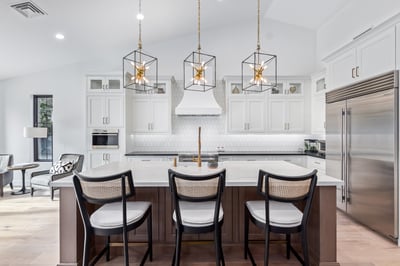 Transitional white kitchen with stainless appliances and island bar in Scottsdale custom home by Kitchens by Good Guys.