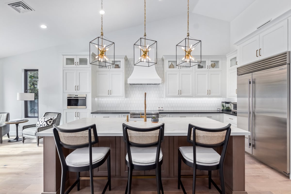 Transitional white kitchen with stainless appliances and island bar in Scottsdale custom home by Kitchens by Good Guys.