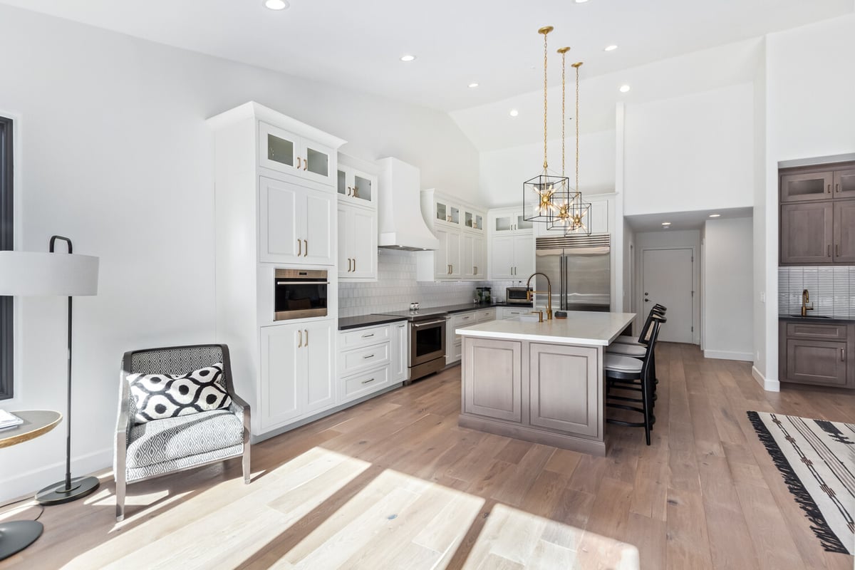 White custom kitchen with pendant lighting and island seating in Scottsdale home by Kitchens by Good Guys.