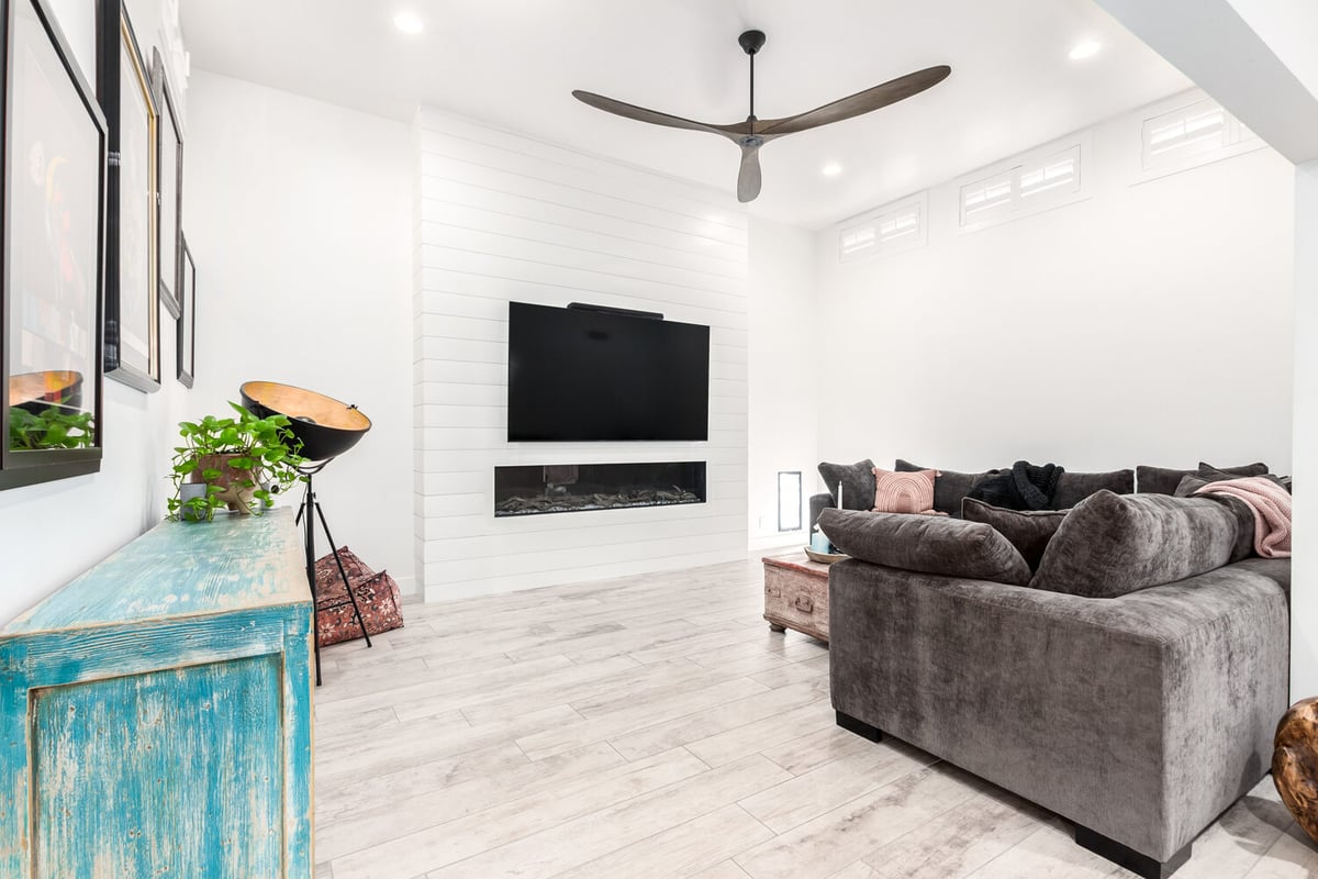 Contemporary living space featuring white shiplap fireplace wall in Paradise Valley custom home by Kitchens by Good Guys.