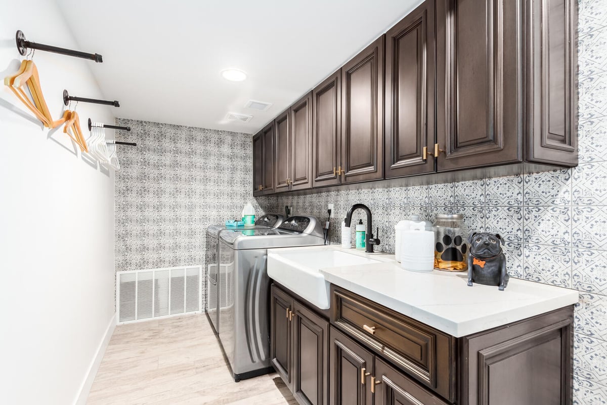 Elegant laundry room with dark cabinetry and patterned tile in Phoenix custom home by Kitchens by Good Guys.