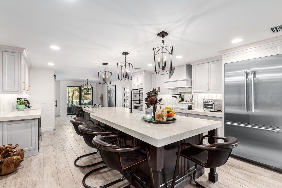 Gourmet kitchen featuring oversized island and statement lighting in Paradise Valley home by Kitchens by Good Guys.