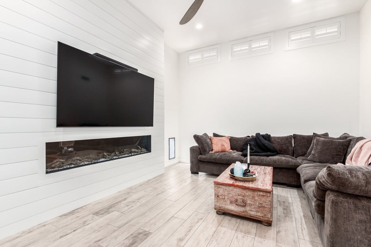 Minimalist living room with fireplace and TV in a Fountain Hills, AZ custom home by Kitchens by Good Guys.