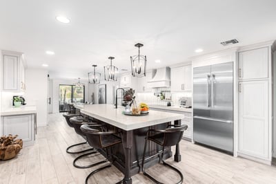 Modern kitchen island with fruit centerpiece and view into cozy living room in Phoenix, AZ by Kitchens by Good Guys.