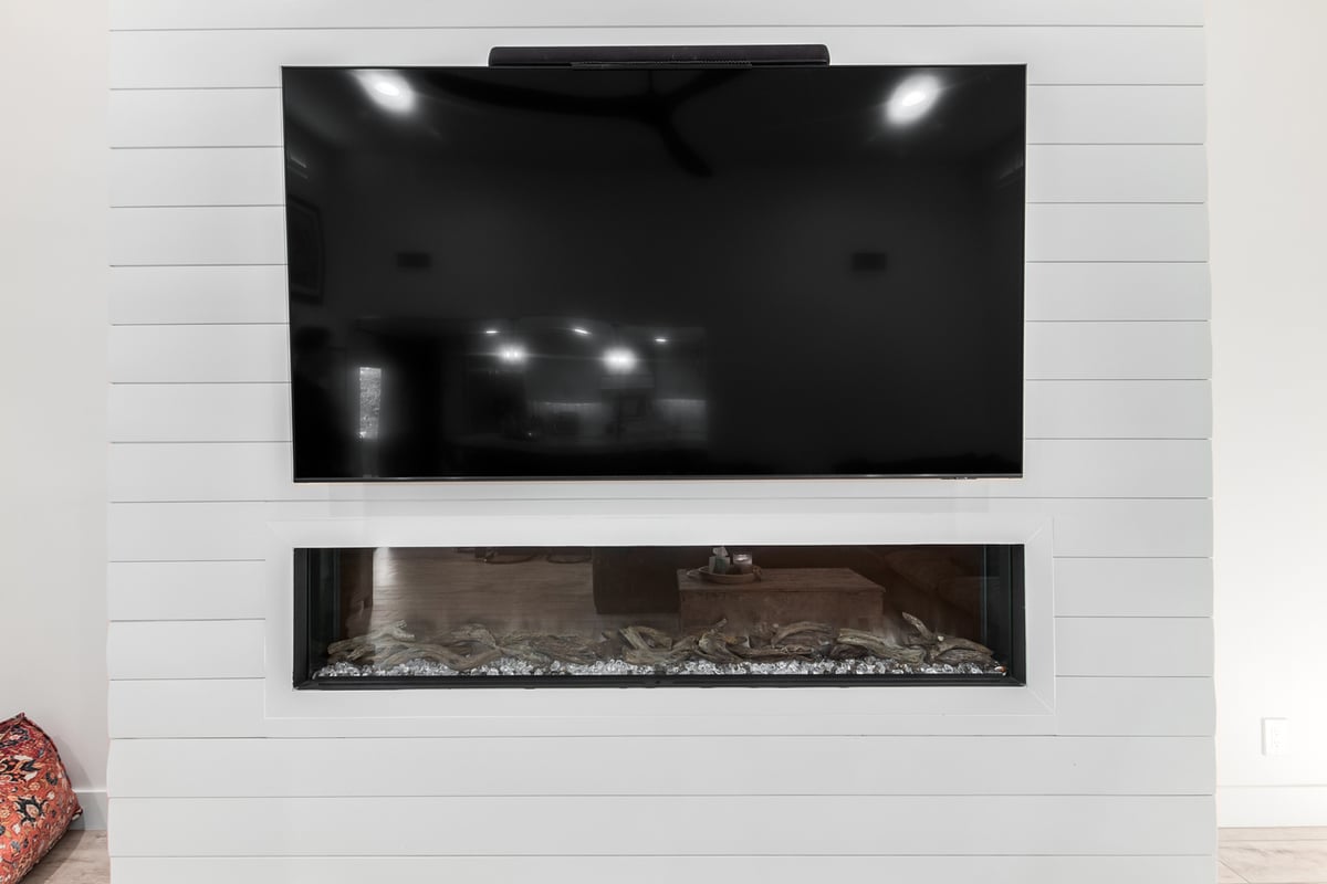 Sleek TV and fireplace combo in Paradise Valley, AZ home by Kitchens by Good Guys.