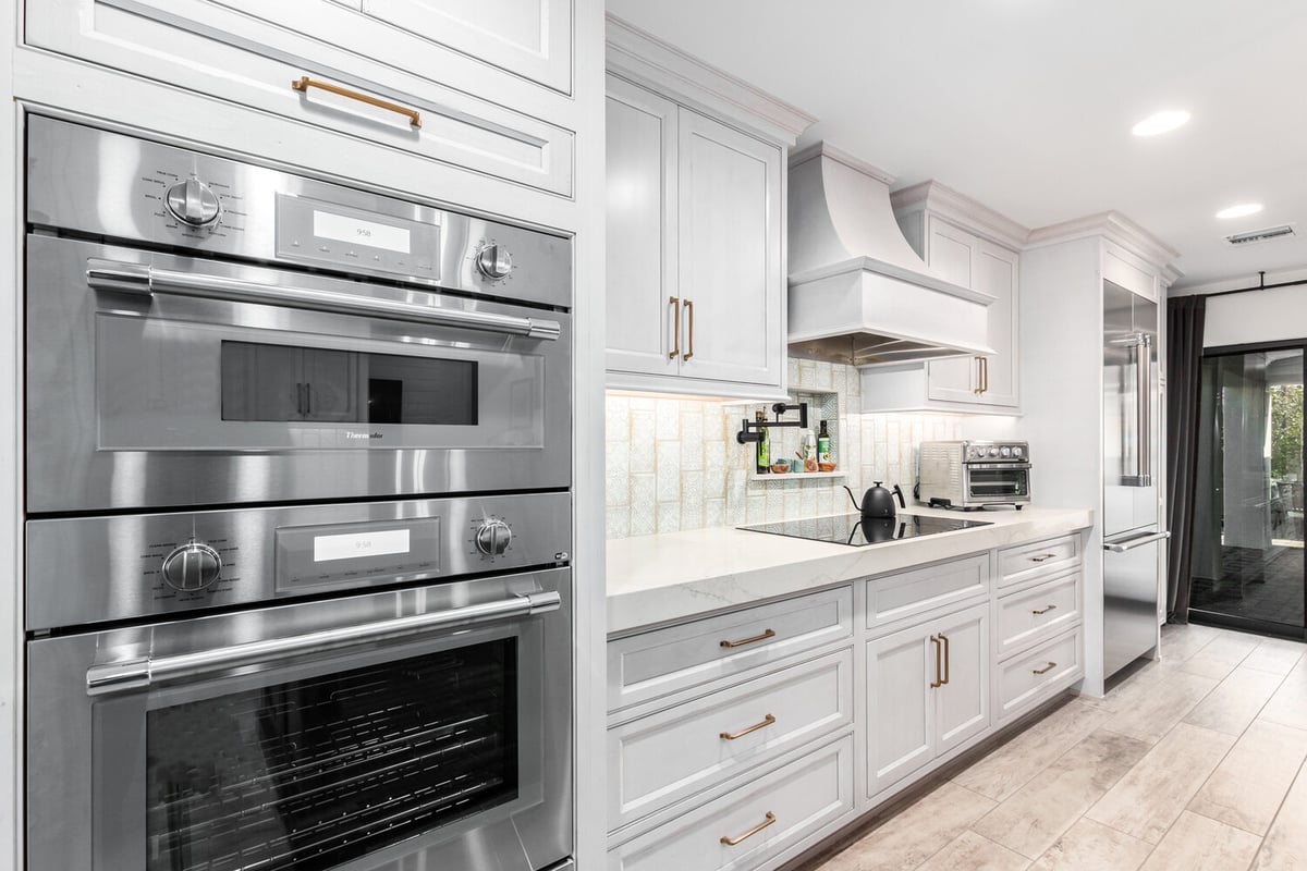 Sleek built-in double oven and modern cooktop area in Paradise Valley custom kitchen by Kitchens by Good Guys.