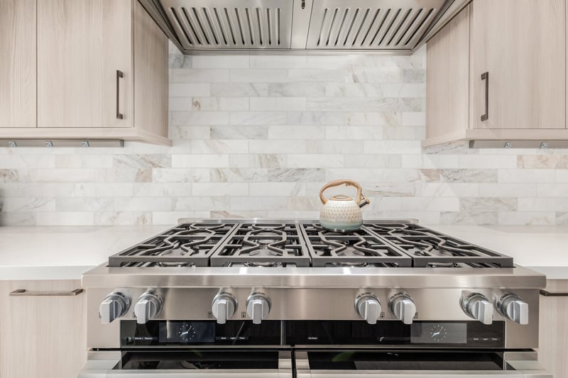 Clean backsplash and premium cooktop in Rio Verde custom home by Kitchens by Good Guys.