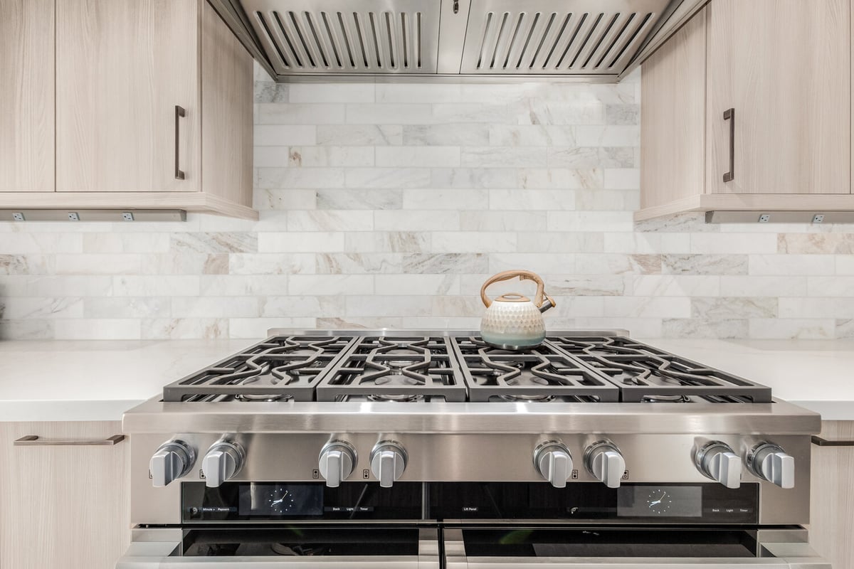 Clean backsplash and premium cooktop in Rio Verde custom home by Kitchens by Good Guys.