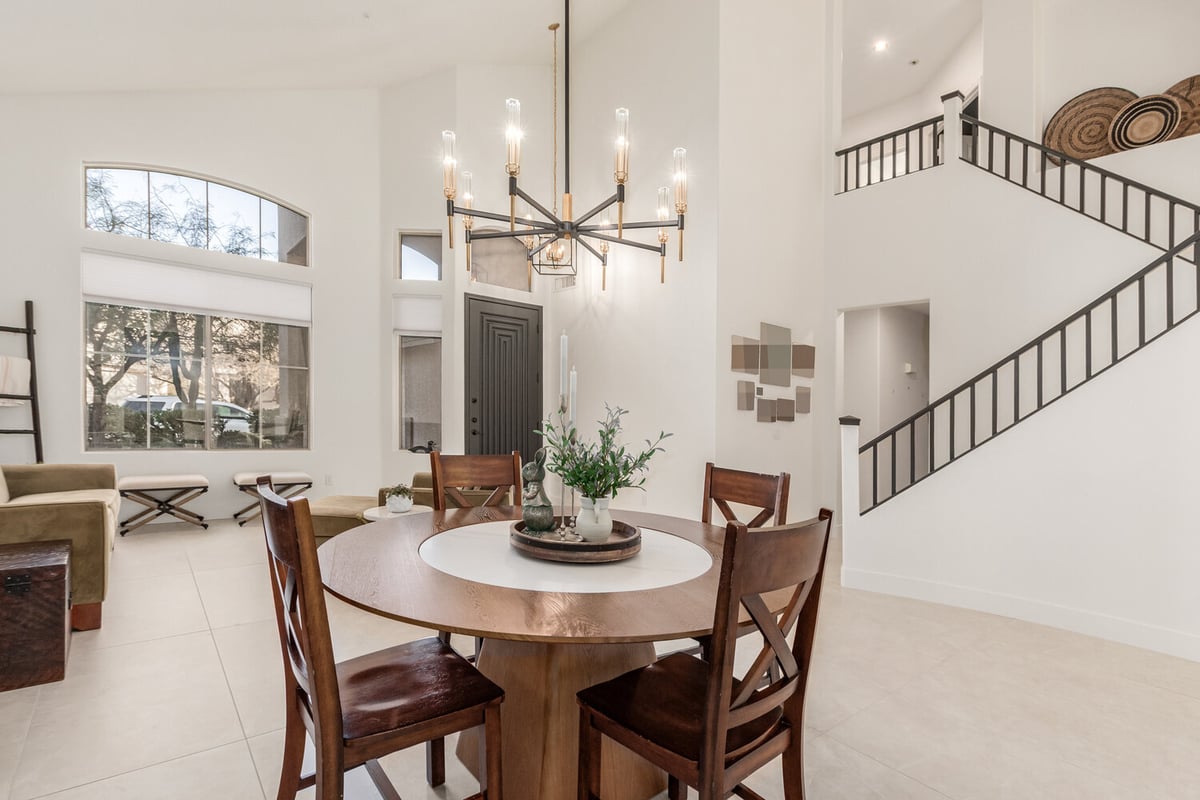 Elegant entry and dining space with black door and modern lighting in Scottsdale home by Kitchens by Good Guys.