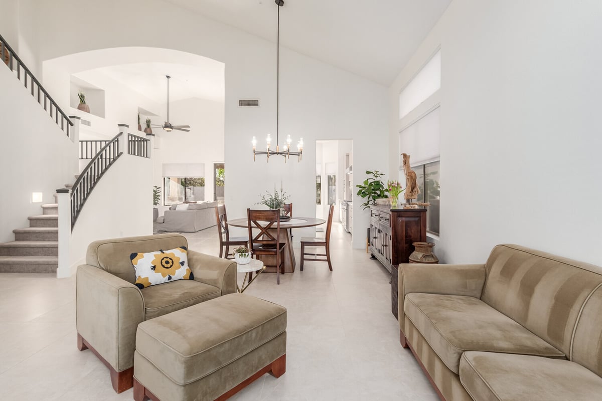 Elegant living and dining area with curved staircase in Scottsdale by Kitchens by Good Guys.