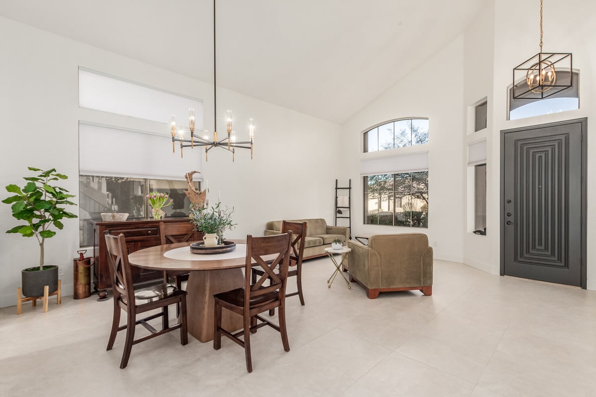 Modern dining space with stylish chandelier and large windows in Mesa custom home by Kitchens by Good Guys.