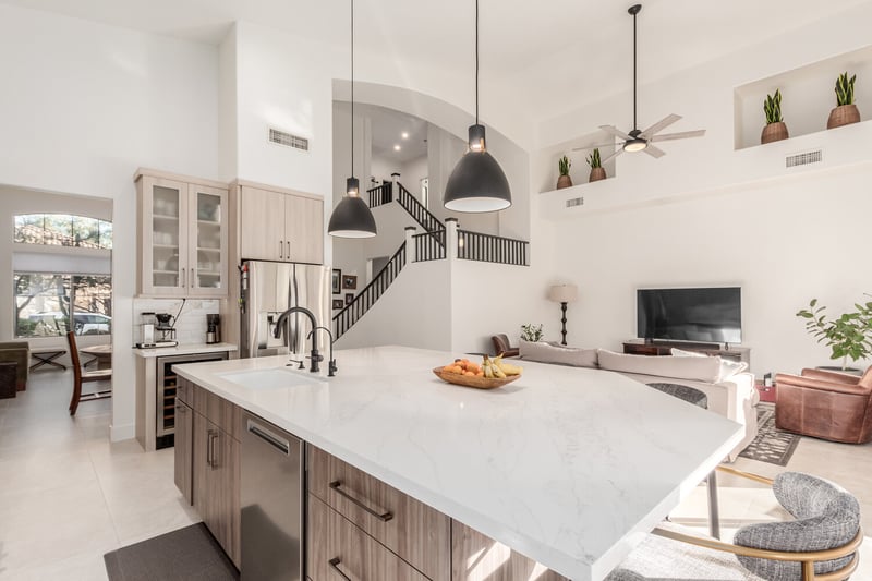Open kitchen and living room layout with staircase view in Fountain Hills home by Kitchens by Good Guys