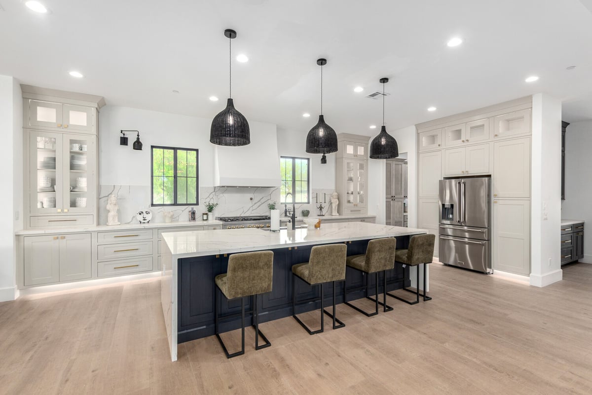 Arizona custom home kitchen featuring large island, pendant lighting, and open shelving by Kitchens by Good Guys.