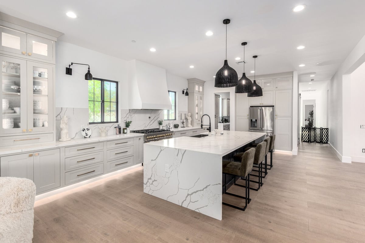 Expansive custom kitchen with waterfall island and pendant lighting in Scottsdale by Kitchens by Good Guys.
