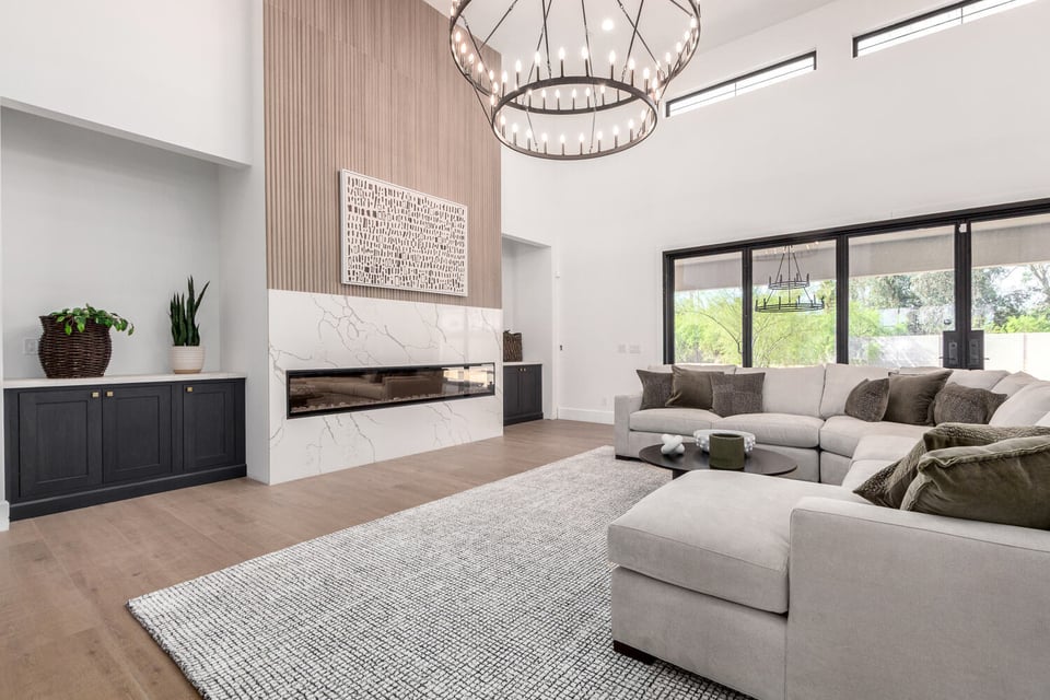 Luxurious living room with marble fireplace and designer lighting in Arizona custom home.