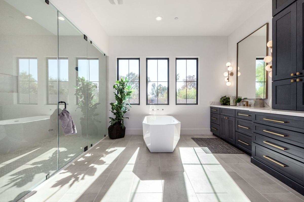 Spacious custom bathroom in Scottsdale with freestanding tub and floor-to-ceiling windows by Kitchens by Good Guys.