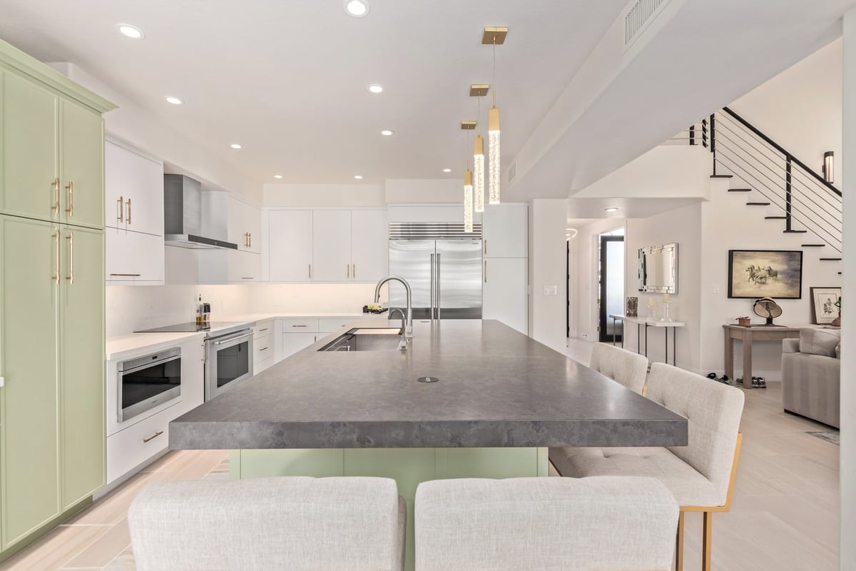 Elegant kitchen island with waterfall edge and pendant lighting in Arizona by Kitchens by Good Guys.