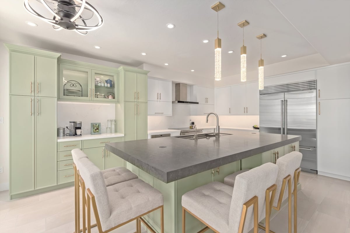 Luxury custom kitchen in Scottsdale with large island, pendant lights, and mint green cabinetry.