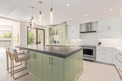 Sleek kitchen design with soft green cabinetry and large island in Arizona custom home.