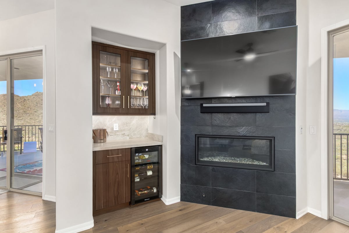 Stylish custom home interior featuring dark slate fireplace and built-in wine bar in Phoenix, AZ by Kitchens by Good Guys.