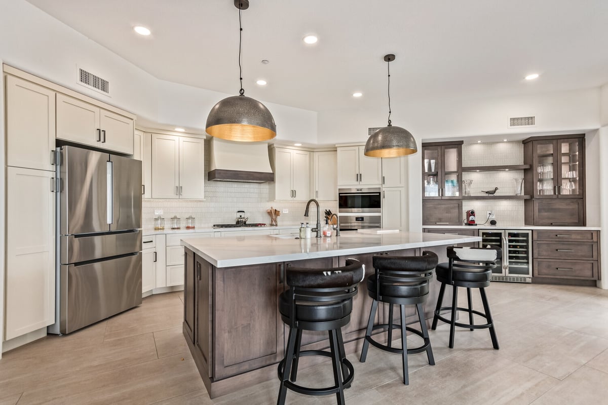 White and wood kitchen with pendant lights by Kitchens by Good Guys in Scottsdale, Arizona