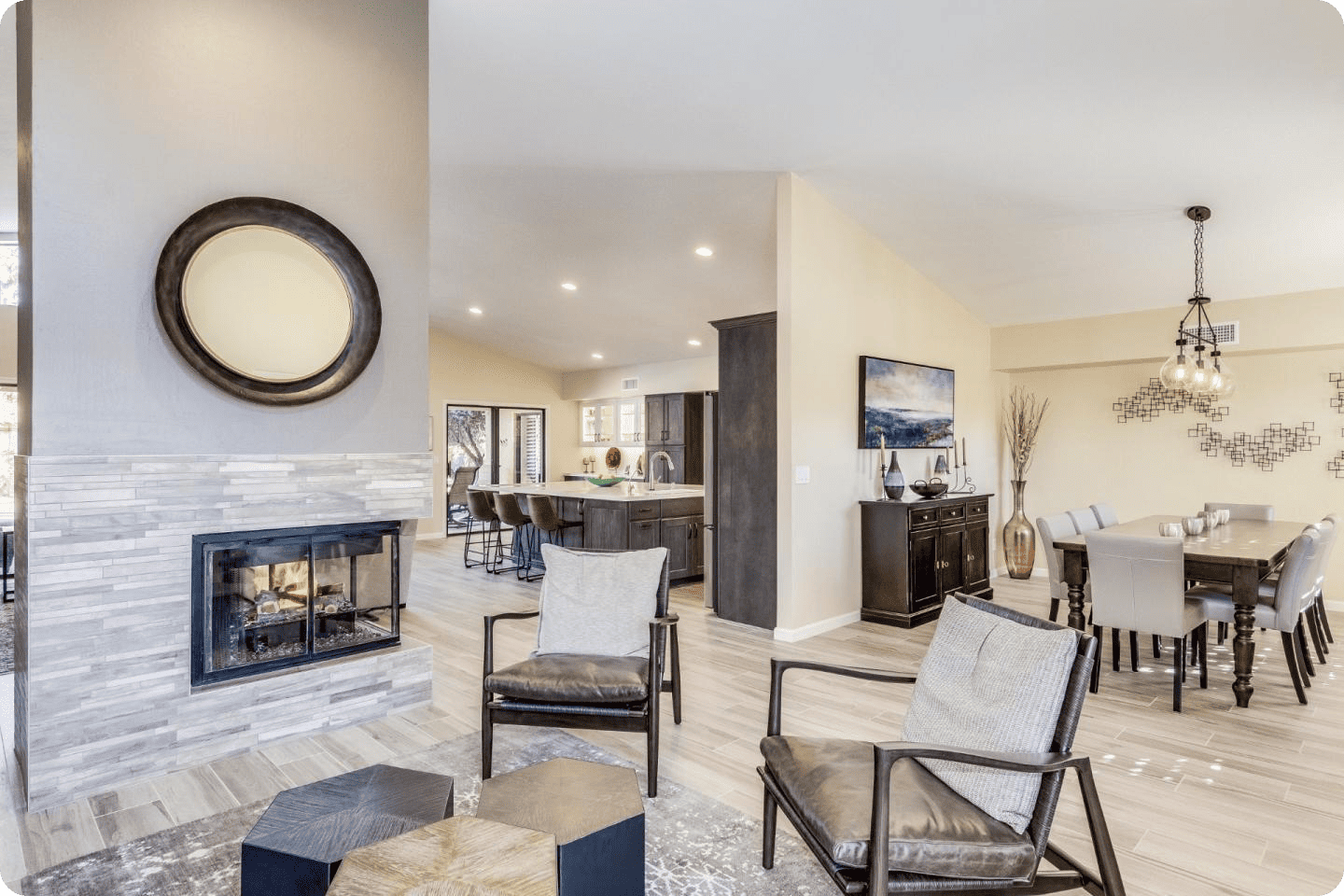 Open-concept living and dining space in the Phoenix area featuring a modern fireplace, neutral tones, and a spacious kitchen island