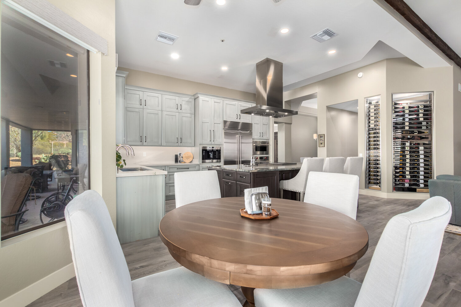 Open-concept kitchen and dining area with wine display in Scottsdale, AZ by Kitchens by Good Guys Open-concept kitchen and dining area with wine display in Scottsdale, AZ by Kitchens by Good Guys