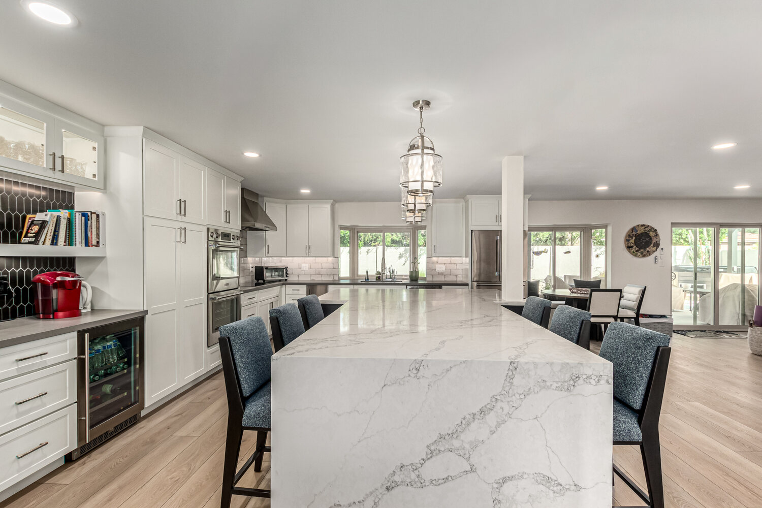 Large quartz island and stylish pendant lighting in a Scottsdale custom kitchen by Kitchens by Good Guys.