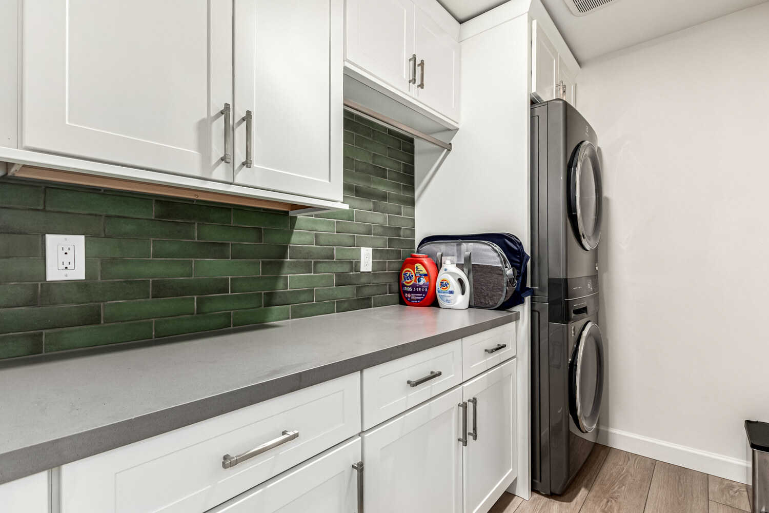 Laundry room remodel with green tile backsplash and stackable washer-dryer in Scottsdale by Kitchens by Good Guys