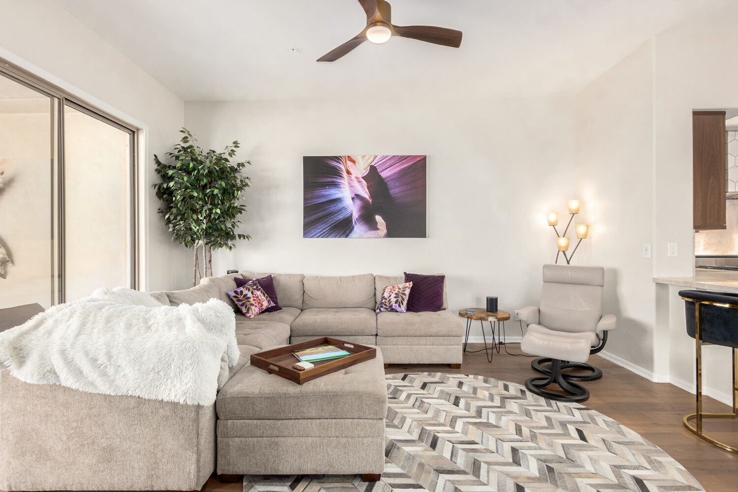 Light-filled living room with stylish sectional in Fountain Hills custom home by Kitchens by Good Guys.